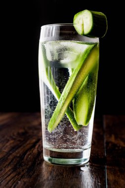 Salatalık kokteyl votka ve tonik koyu ahşap yüzeyi ile.