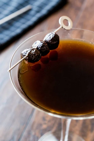 Black Manhattan Cóctel con aceitunas sobre superficie de madera oscura . —  Fotos de Stock