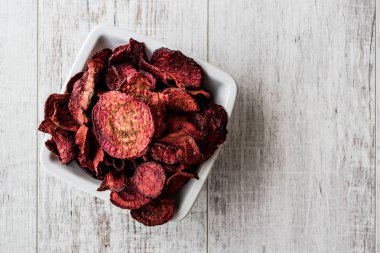 Mor pişmiş pancar cips beyaz tahta yüzeyi.