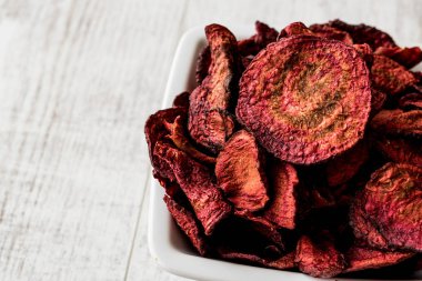 Mor pişmiş pancar cips beyaz tahta yüzeyi.