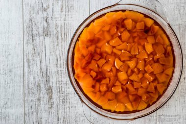 Şeftali Reçeli cam kase beyaz tahta yüzeyi.