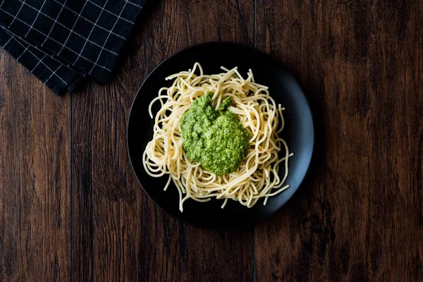 Spaghetti con salsa di pesto su superficie di legno scuro . — Foto Stock