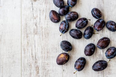 Beyaz ahşap yüzeyde Damson Erik.