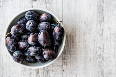 Beyaz ahşap yüzeyde Damson Erik.