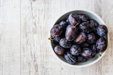 Beyaz ahşap yüzeyde Damson Erik.