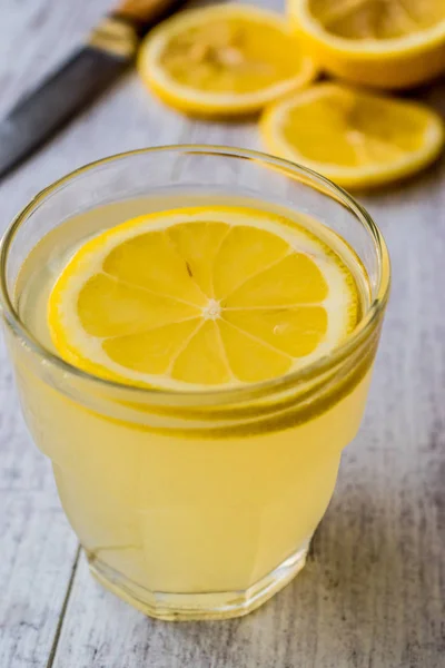 Licor de limón Limoncello con limón sobre superficie de madera blanca . —  Fotos de Stock