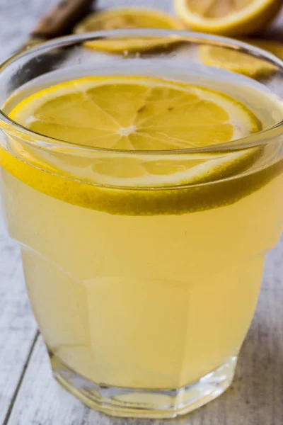 Licor de limón Limoncello con limón sobre superficie de madera blanca . —  Fotos de Stock