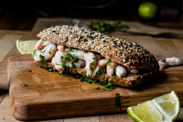 Shrimp Sandwich with lime on wooden surface.