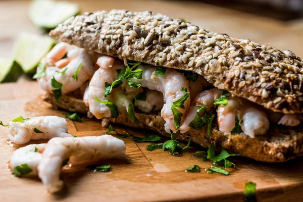 Shrimp Sandwich with lime on wooden surface.