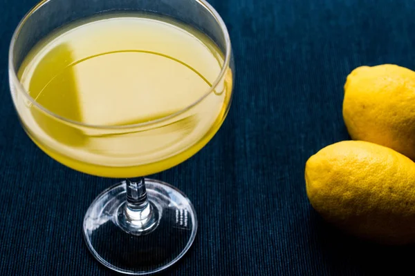 Licor de limón Limoncello con limón sobre superficie azul oscuro —  Fotos de Stock