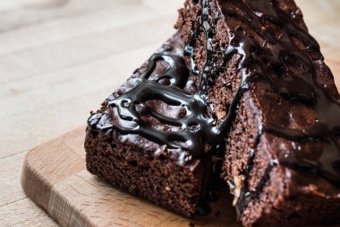 Ahşap yüzey üzerinde çikolata soslu brownie kek.