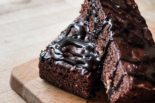 Bolo Brownie com molho de chocolate na superfície de madeira . — Fotografia de Stock