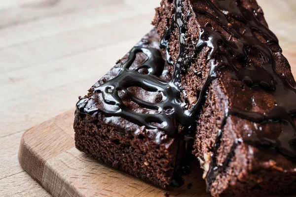 Ahşap yüzey üzerinde çikolata soslu brownie kek.