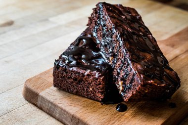 Ahşap yüzey üzerinde çikolata soslu brownie kek.