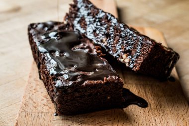 Ahşap yüzey üzerinde çikolata soslu brownie kek.