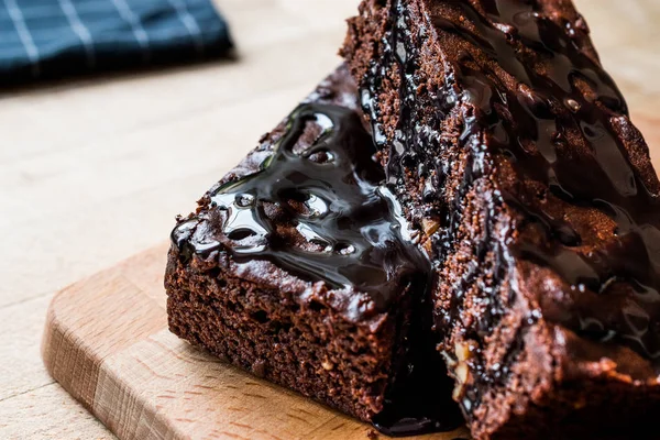 Ahşap yüzey üzerinde çikolata soslu brownie kek.