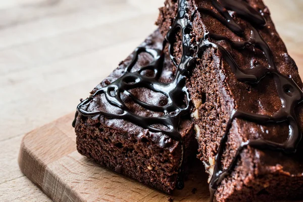 Ahşap yüzey üzerinde çikolata soslu brownie kek.