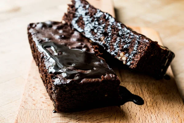 Brownie torta csokoládé öntettel, fa felületre. — Stock Fotó