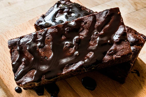 Ahşap yüzey üzerinde çikolata soslu brownie kek.