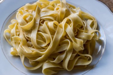 Düz Tagliatelle makarna beyaz plaka.