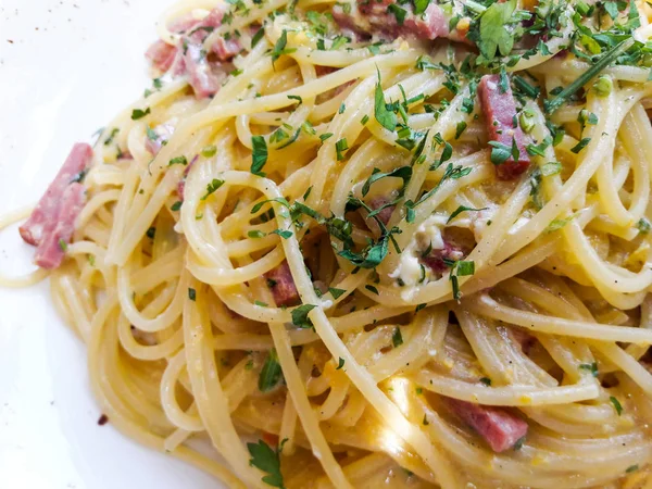 Spagetti Carbonara pastırma ve restoranda krem ile ile doğal ışık vurdu.