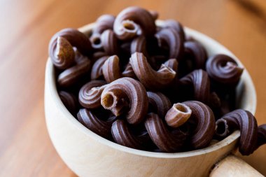 Ahşap Kepçe içinde üzüm tohum ile ham Brown makarna.