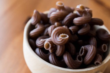 Ahşap Kepçe içinde üzüm tohum ile ham Brown makarna.