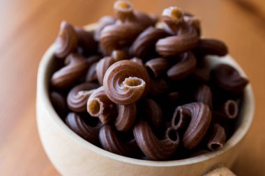 Ahşap Kepçe içinde üzüm tohum ile ham Brown makarna.