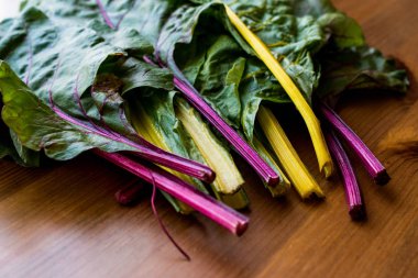 Ahşap yüzey üzerinde ham organik gökkuşağı Swiss pazı dikti.