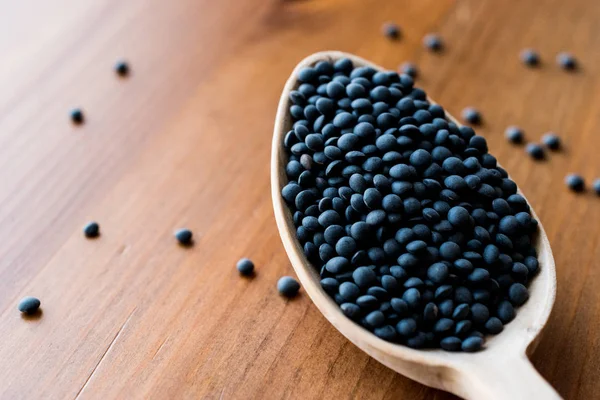 Siyah havyar mercimek tahta kaşık içinde.