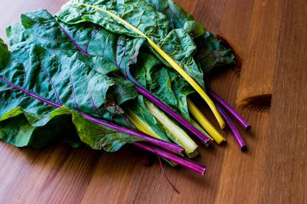 Ahşap yüzey üzerinde ham organik gökkuşağı Swiss pazı dikti.