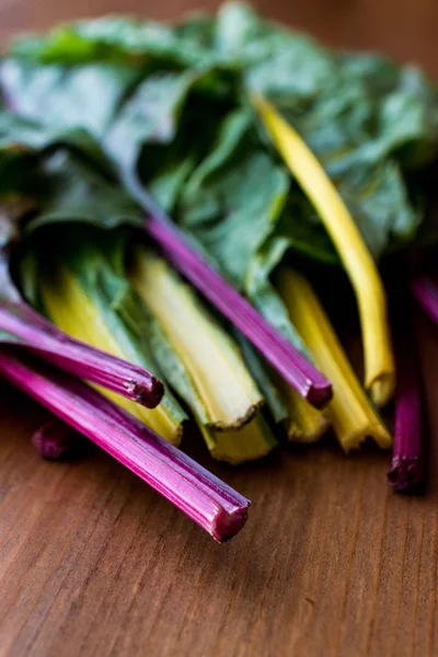 Ahşap yüzey üzerinde ham organik gökkuşağı Swiss pazı dikti.