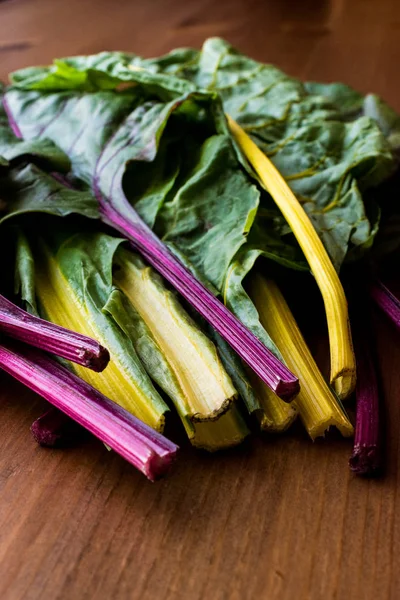 Ahşap yüzey üzerinde ham organik gökkuşağı Swiss pazı dikti.