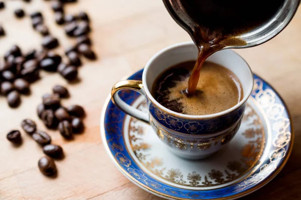 Verter el café turco en la taza tradicional . — Foto de Stock