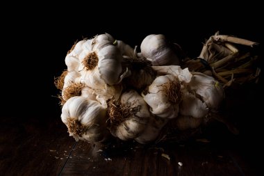 Diş sarımsak ve ampul ahşap yüzey üzerinde. Karanlık Moody