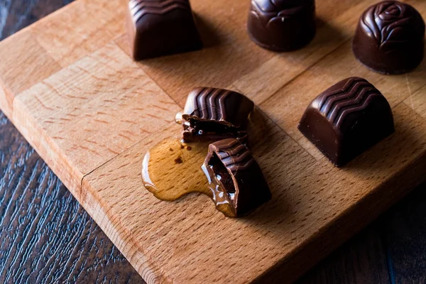 El licor fluye del chocolate en la superficie de madera . — Foto de Stock