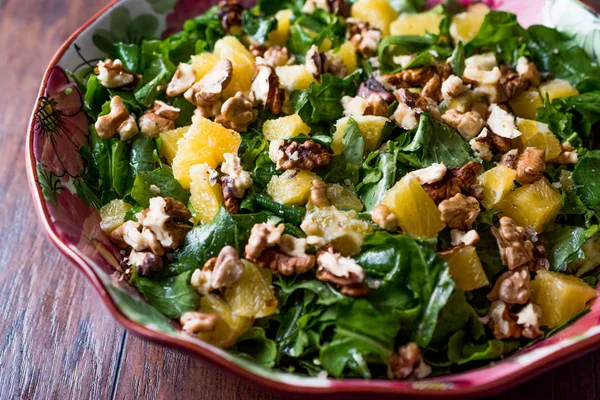 Pineapple Salad with greens on a wooden surface.