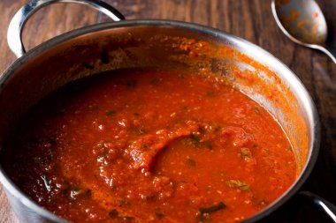 Metal tencerede otlar ile domates sosu