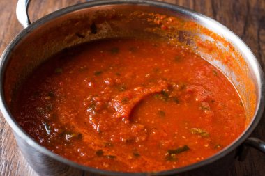 Metal tencerede otlar ile domates sosu