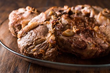 Kuzu etler koyu ahşap yüzey üzerinde cam kapta.