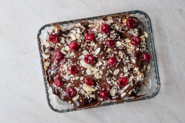 Çikolatalı puding kek kiraz, badem dilimleri ve bisküvi