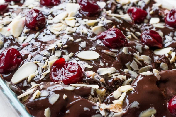 Bolo de pudim de chocolate com cerejas, fatias de amêndoa e biscoitos — Fotografia de Stock