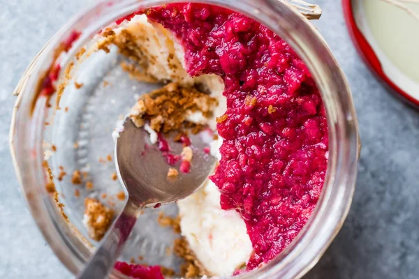 Forest Fruits Cheesecake in Jar with Spoon. / Unfinished Dessert