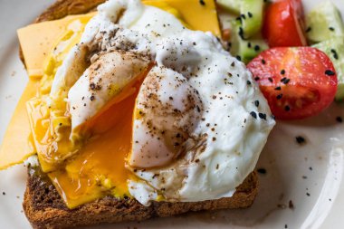 Tost ekmeği kaşar peyniri, balsamik sirke, salata ve siyah susam veya Kimyon tohumu ile haşlanmış yumurta.