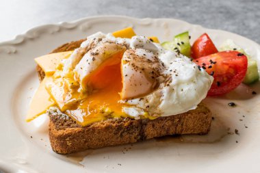 Tost ekmeği kaşar peyniri, balsamik sirke, salata ve siyah susam veya Kimyon tohumu ile haşlanmış yumurta.