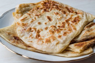 Geleneksel Qutab ya da fırında tavuklu hamur, kıyılmış et veya peynir ile yapılan.