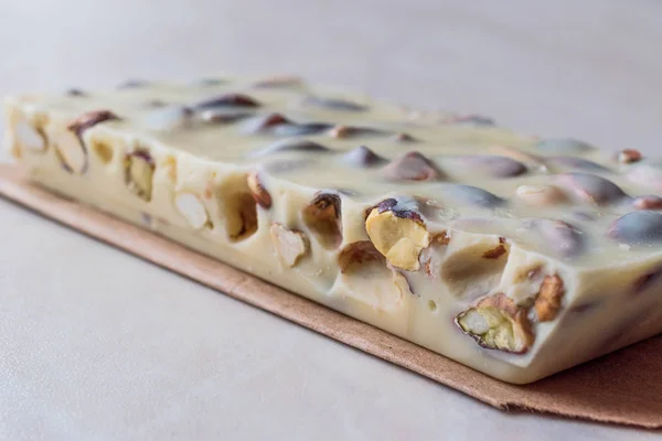 Witte chocolade stuk met pistache op marmeren oppervlak. — Stockfoto