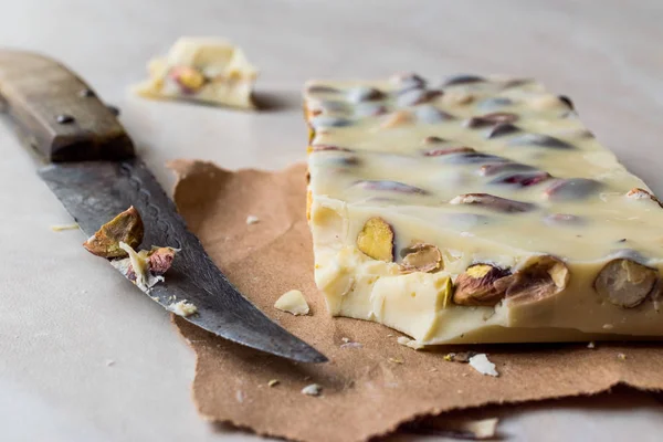 Pezzo di cioccolato bianco con pistacchio su superficie di marmo . — Foto Stock