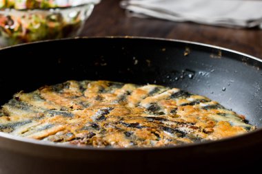Taze kızarmış sardalye salata ahşap yüzeyi ile tavada.