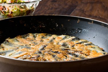 Taze kızarmış sardalye salata ahşap yüzeyi ile tavada.
